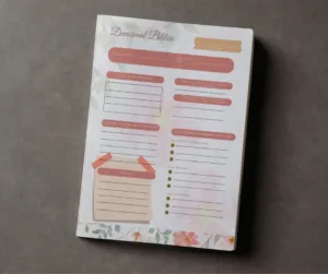 Mockup de libreta con hoja impresa de plantilla devocional bíblica floral con guías de estudio y sección de oración.